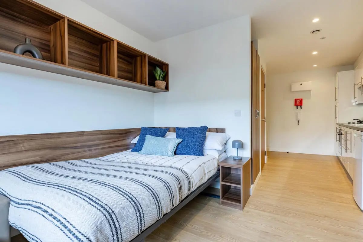 Bed with blue pillows and shelves Bedroom at The Printworks in Exeter Student Accommodation