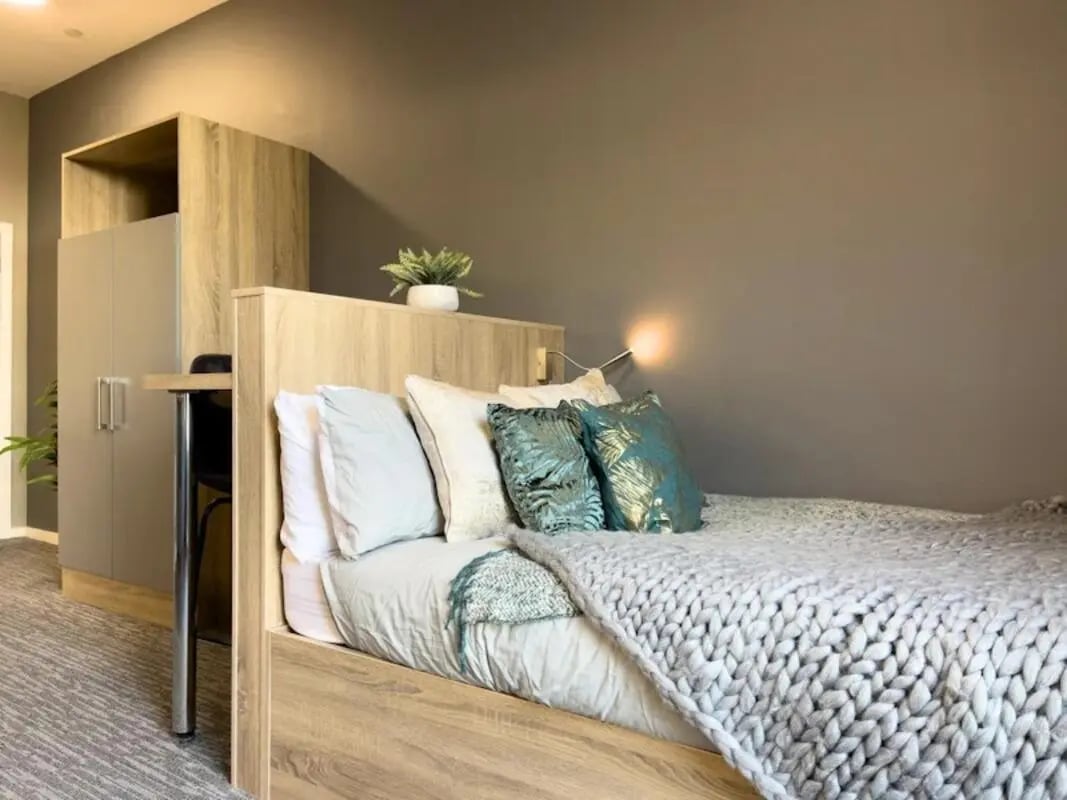 Bed with pillows and chunky knit blanket Bedroom at Justice Mill Studios in Aberdeen Student Accommodation
