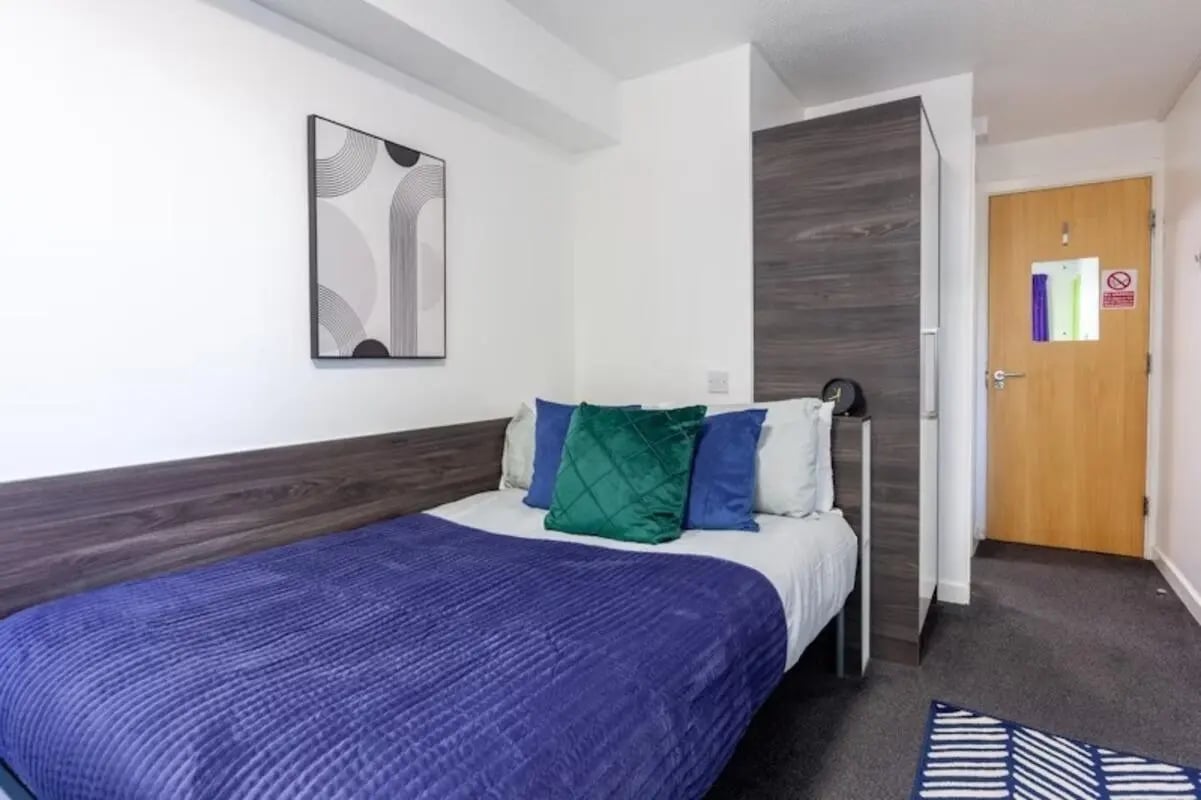 Bed with blue and green pillows closet door bedroom at Paddington Park House in Liverpool Student Accommodation