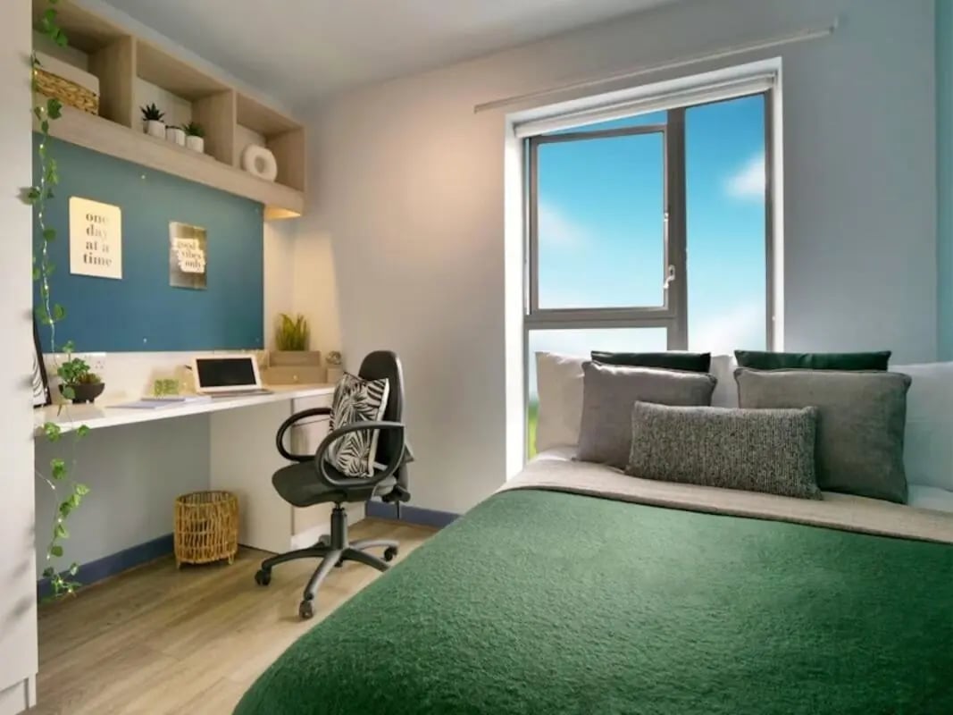 Desk with laptop chair bed with green blanket Bedroom at Bright House in Kingston Upon Thames Student Accommodation