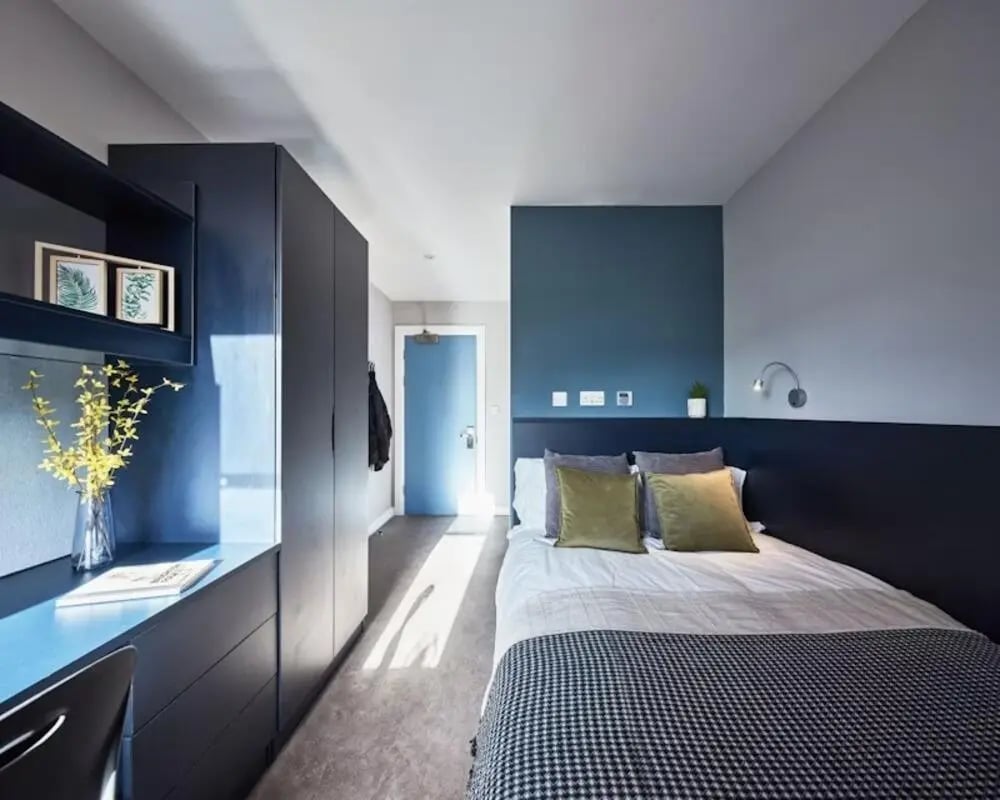 Bed desk wardrobe and blue door bedroom at Alumno Falmer in Brighton Student Accommodation
