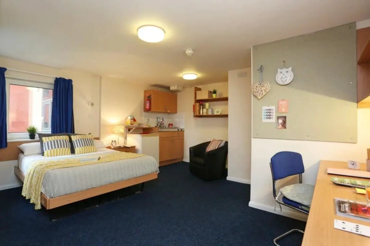 Bed kitchenette black armchair and desk studio apartment at The Print House in Loughborough Student Accommodation