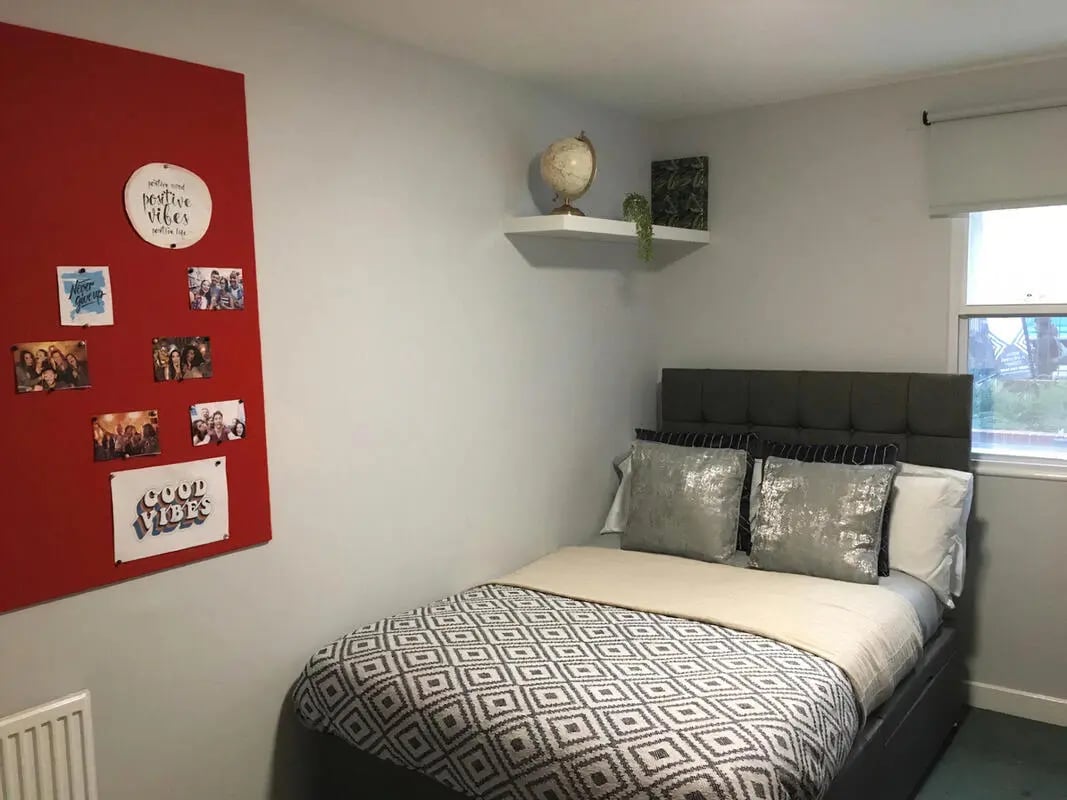 Bed with photos and globe Bedroom at Dean House in London Student Accommodation