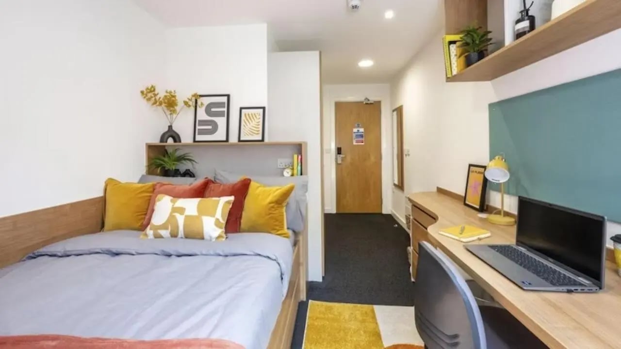 Bed with pillows desk with laptop and chair bedroom at The Elements in Sheffield Student Accommodation