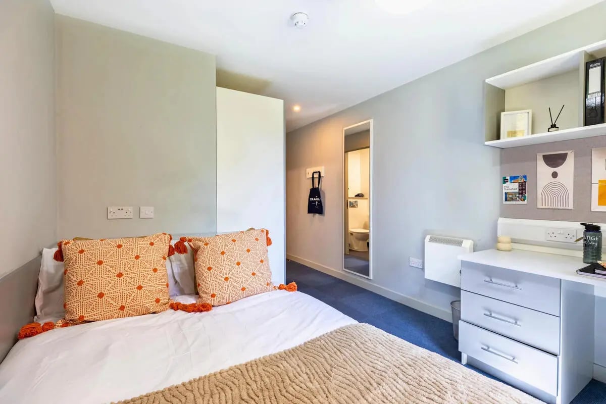 Bed with orange pillows desk and ensuite bathroom Bedroom at The Tramshed in Preston Student Accommodation