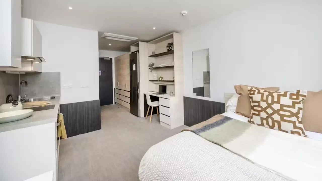 Studio apartment with bed desk kitchen and wardrobe bedroom at Hythe Mills in Colchester Student Accommodation