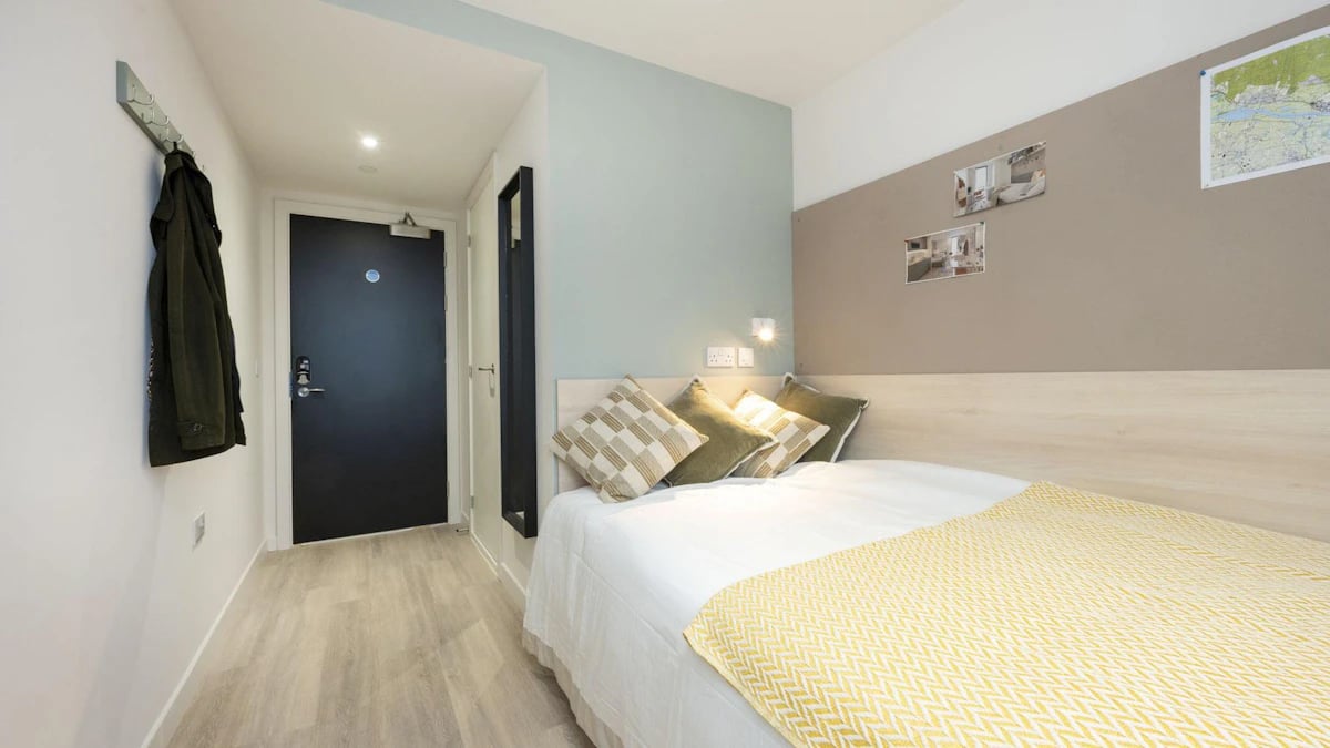 Bed with yellow blanket and pillows bedroom at Parklands in Dundee Student Accommodation