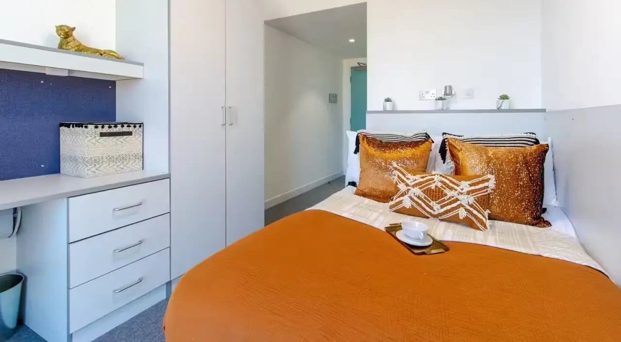 Bed with cushions desk and storage bedroom at The Union Leamington in Leamington Spa Student Accommodation