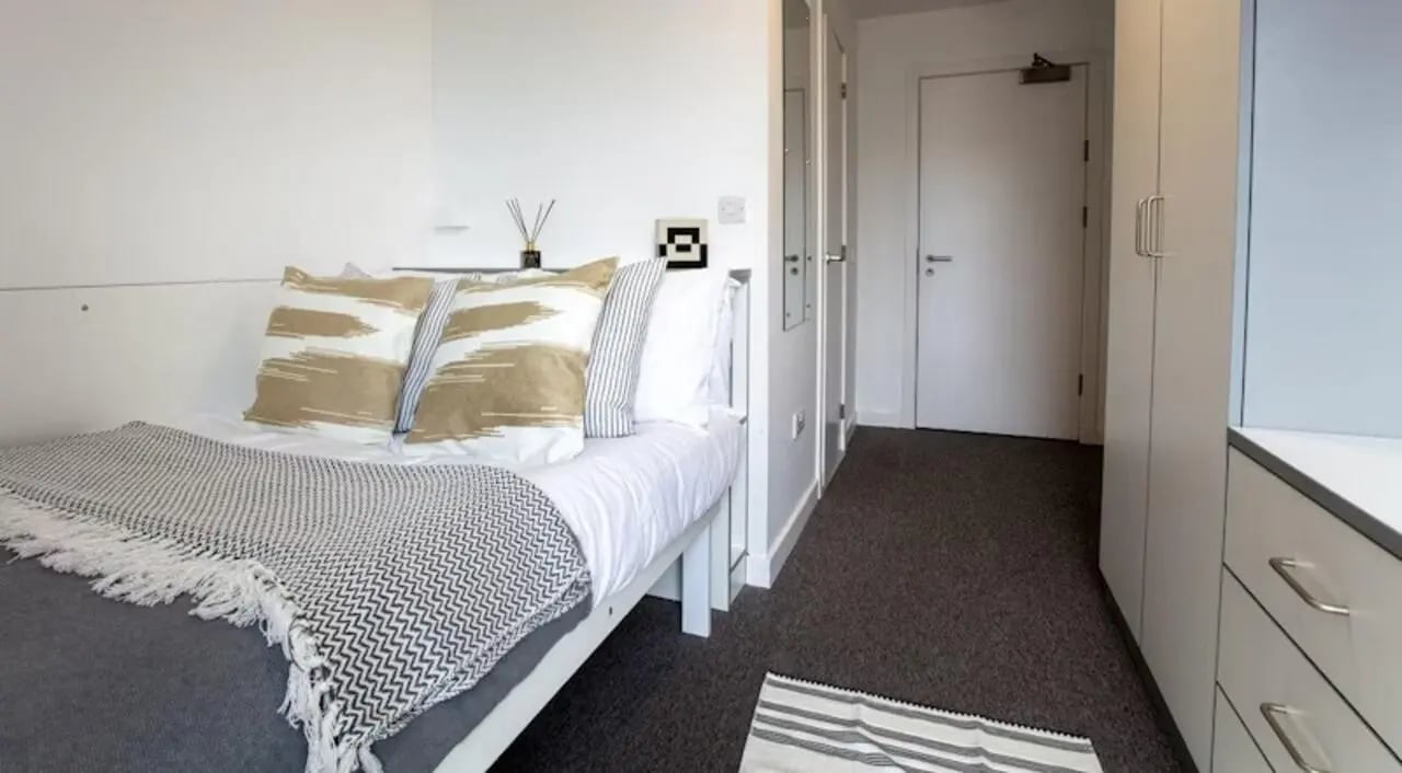 Bed with decorative pillows and patterned blanket bedroom at East Shore in St Andrews Student Accommodation