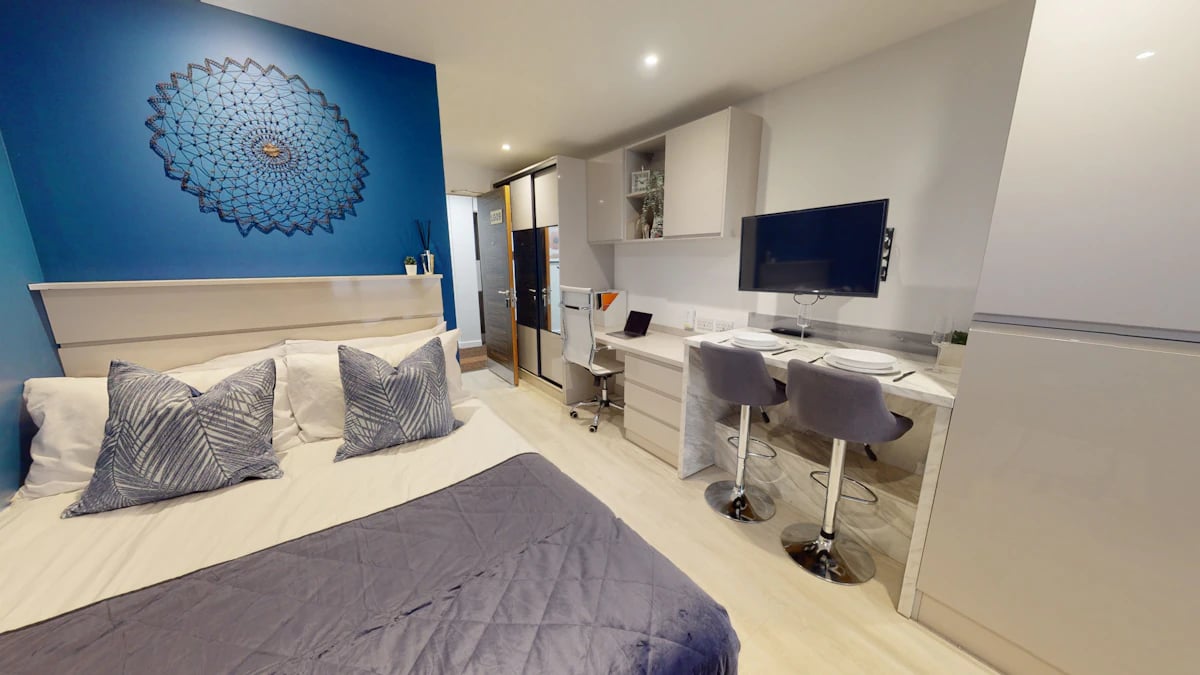 Bed desk chairs TV and kitchen area bedroom at 79 Silver Street in Reading Student Accommodation