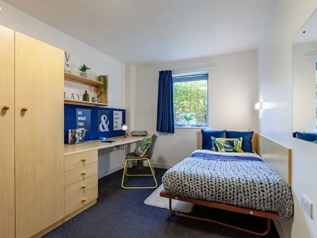 Wardrobe desk bed chair plants window Bedroom at Polhill Park in Bedford Student Accommodation