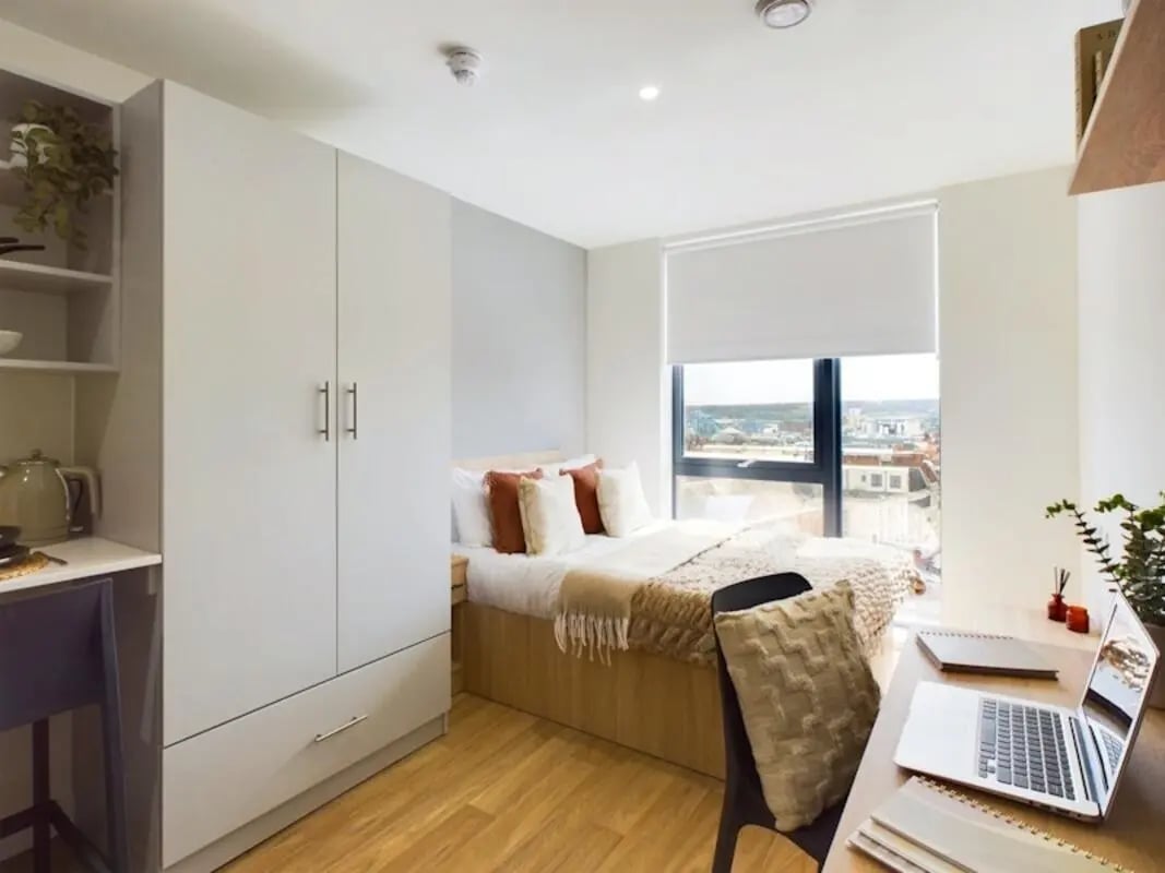 Bed wardrobe desk laptop and kettle bedroom at Straits Aire in Leeds Student Accommodation