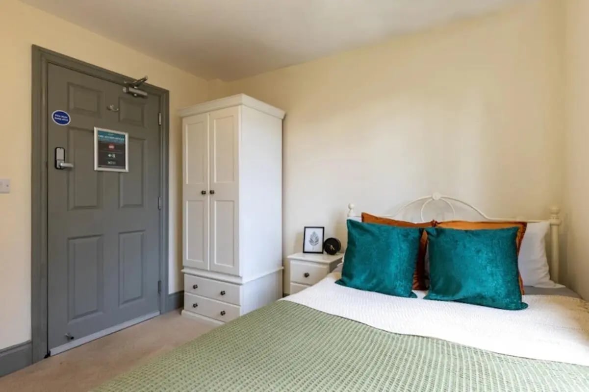 Wardrobe nightstand and bed with pillows bedroom at Mary Morris House in Leeds Student Accommodation
