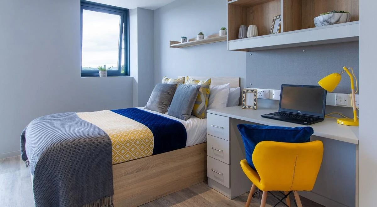 Bed desk laptop chair pillows and window bedroom at Renslade House in Exeter Student Accommodation