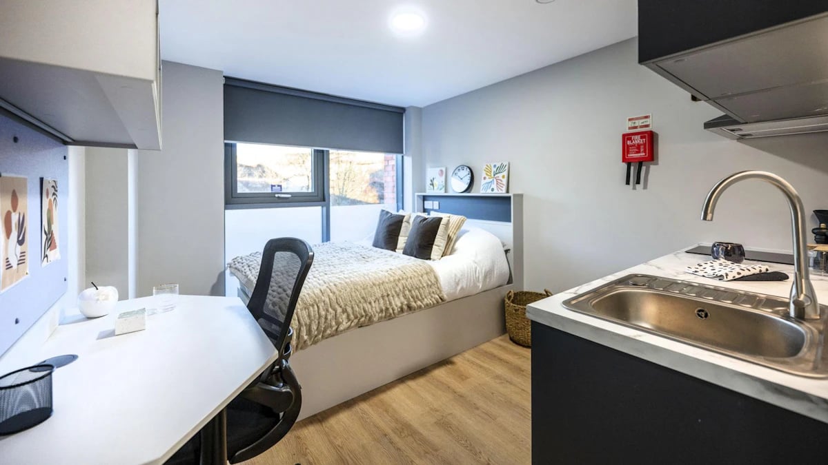 Bed desk chair kitchen sink with fire blanket living area at Clyde Court in Glasgow Student Accommodation