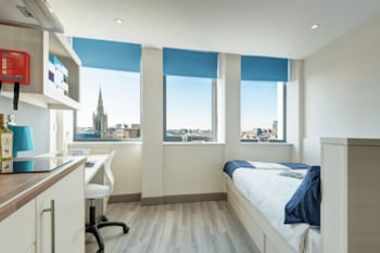 Bedroom with bed desk and kitchenette interior at Mercury House in Bournemouth Student Accommodation