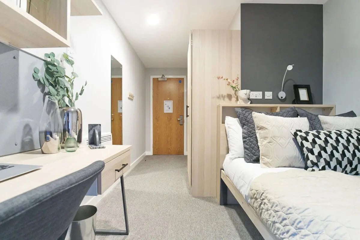Desk bed with pillows and plants bedroom at Straits Manor in Sheffield Student Accommodation