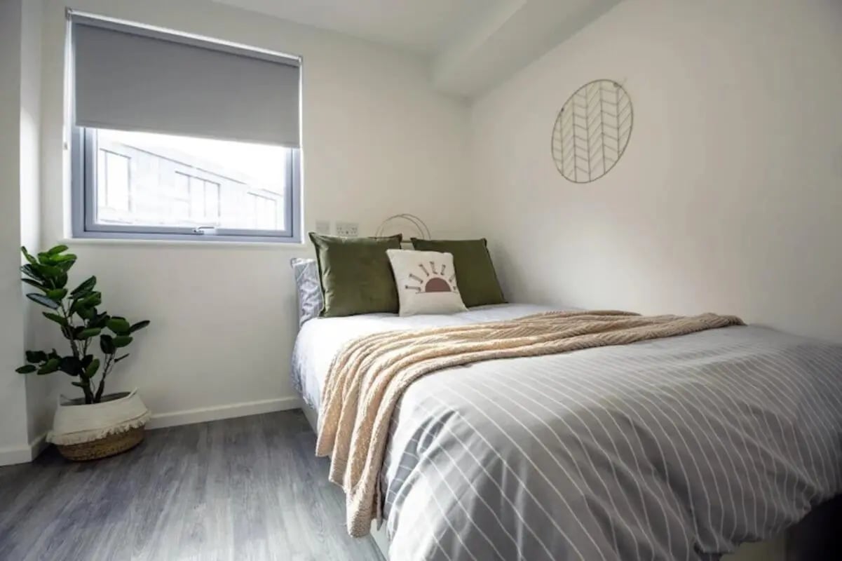 Bed with green pillows and blanket Bedroom at Westcombe House in London Student Accommodation