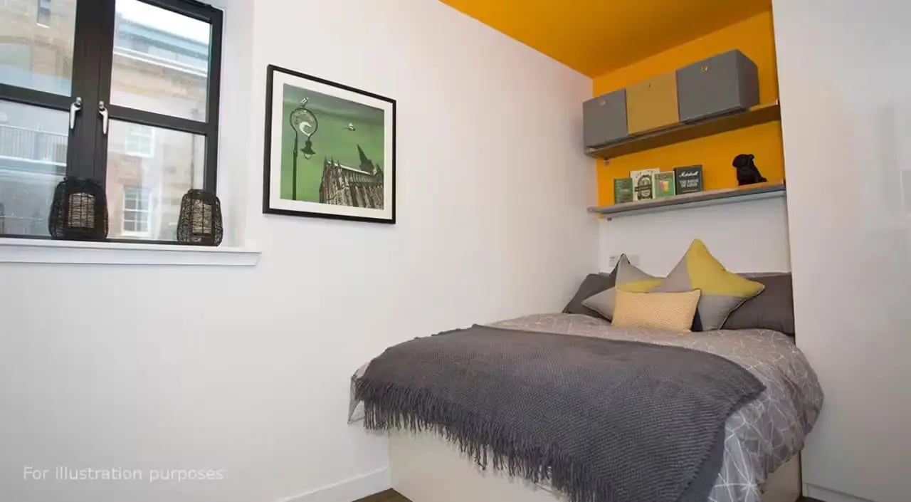 Bed with grey blanket yellow pillows framed picture Bedroom at Riverside Glasgow in Glasgow Student Accommodation