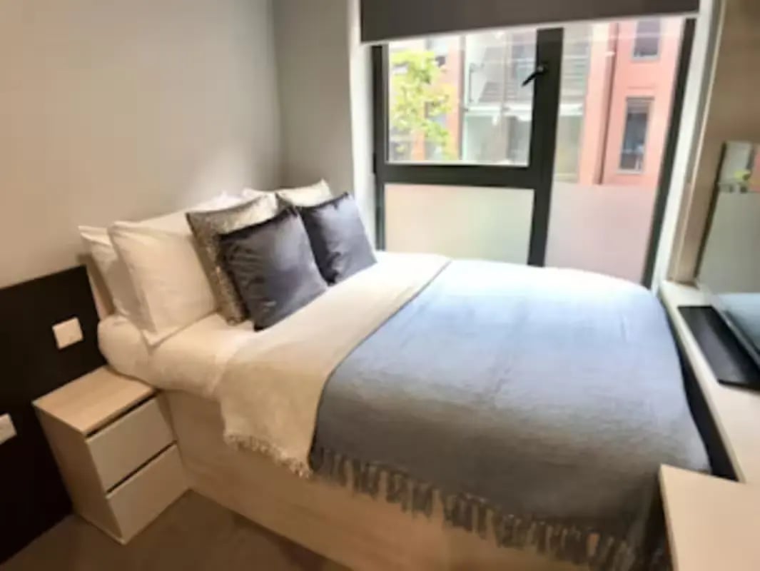 Bed with pillows bedside table and window bedroom at Steel City in Sheffield Student Accommodation