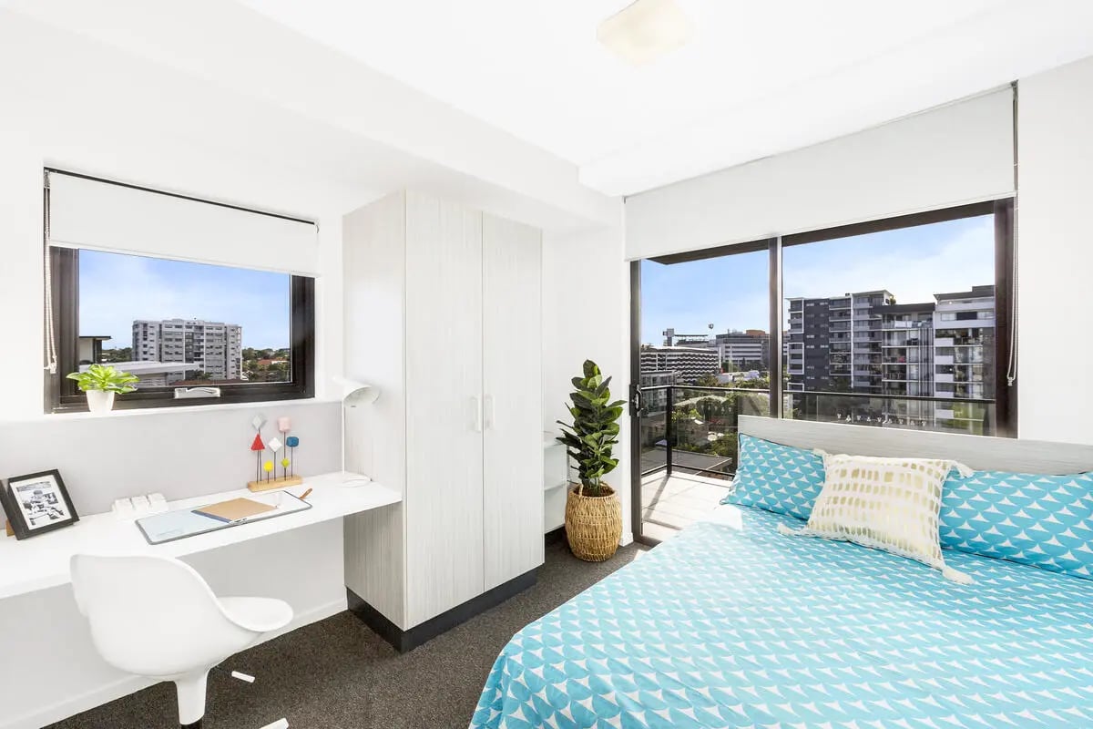 Bed desk wardrobe plant balcony bedroom at Scape Regent in Brisbane Student Accommodation