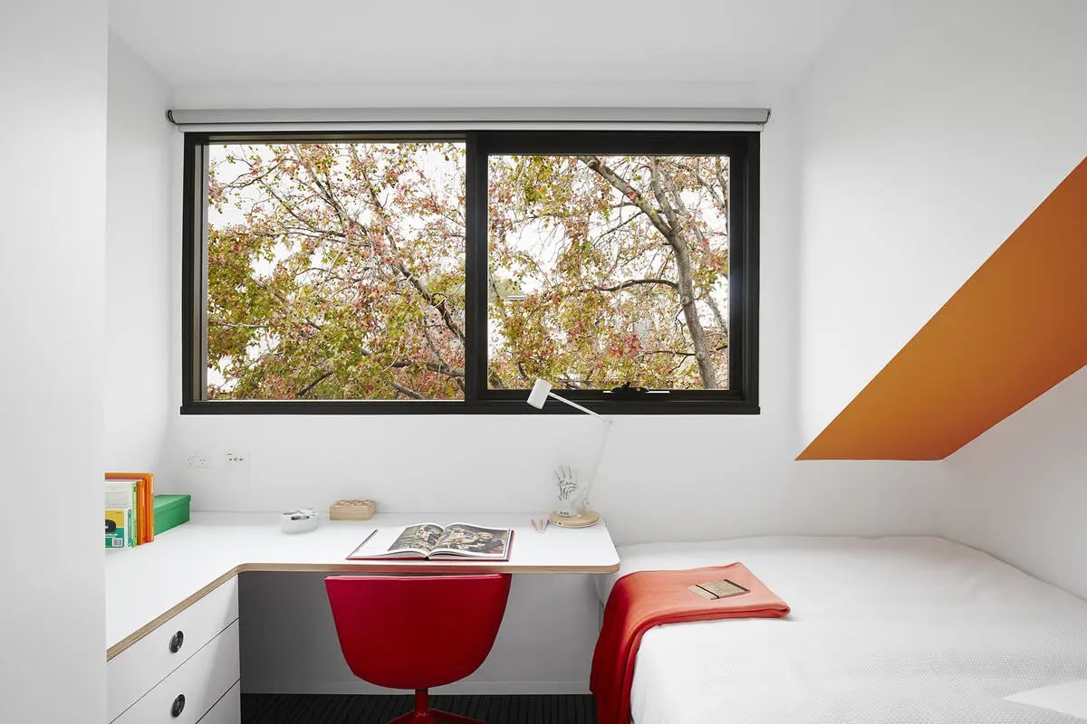 Desk bed books and lamp bedroom at Scape Abercrombie in Sydney Student Accommodation