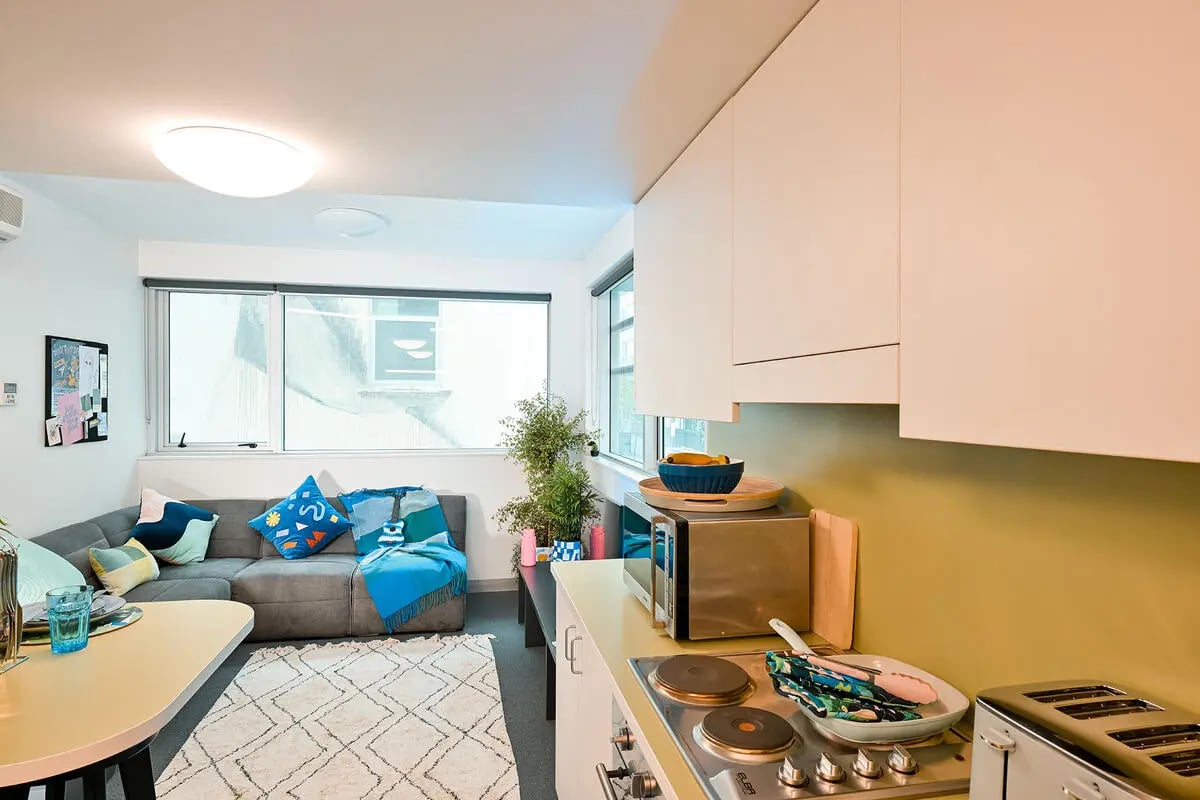 Grey sofa kitchen area with microwave toaster. at Scape Adelaide Central in Adelaide Student Accommodation