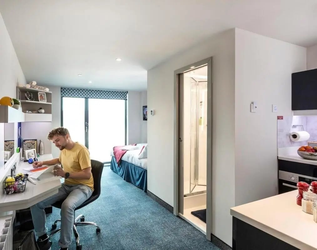 Man studying desk bed shower kitchen exterior at Triumph House in Nottingham Student Accommodation