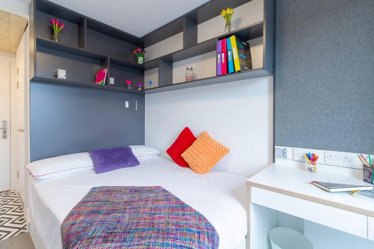 Bed with colorful blanket and pillows desk bedroom at AXO Paradise Student Village in Coventry Student Accommodation