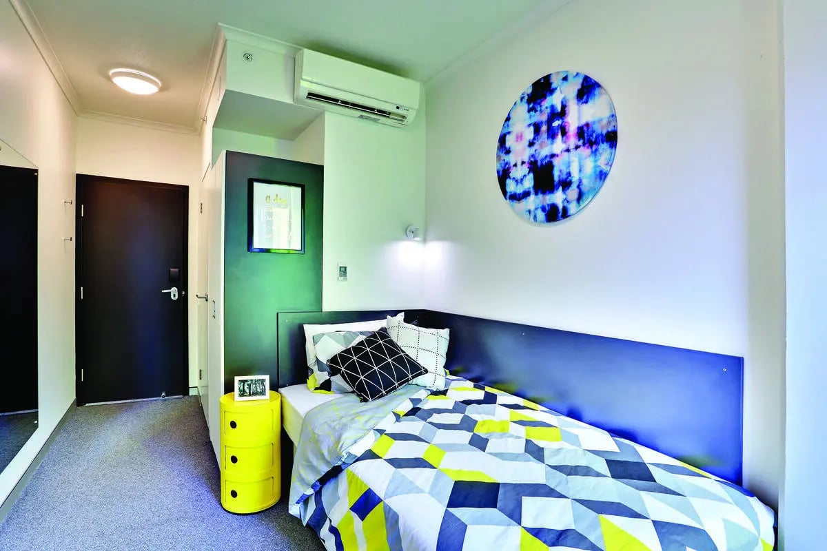 Bed pillows artwork and yellow dresser bedroom at Scape Quay in Sydney Student Accommodation
