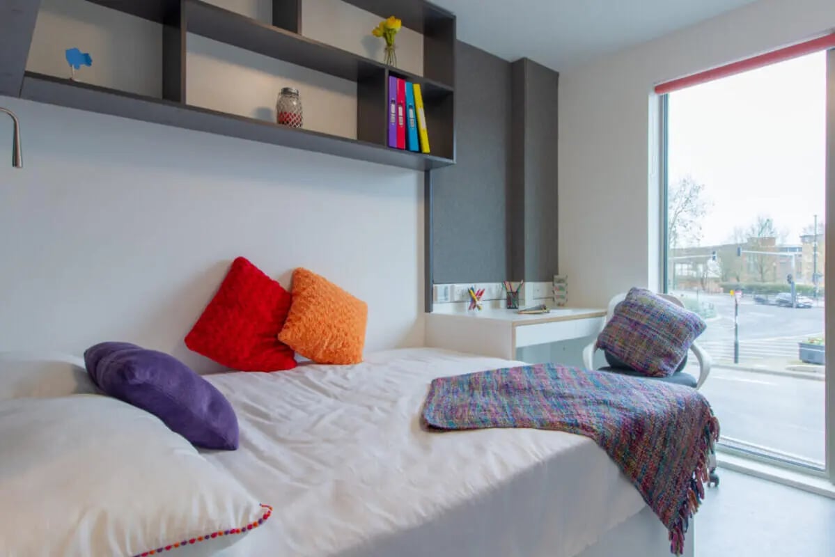 Bed with colorful pillows and desk bedroom at AXO Paradise Student Village in Coventry Student Accommodation