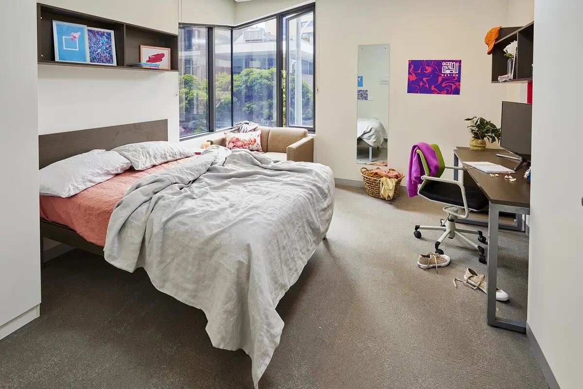Bed desk chair and window student bedroom at Scape Berkeley in Melbourne Student Accommodation