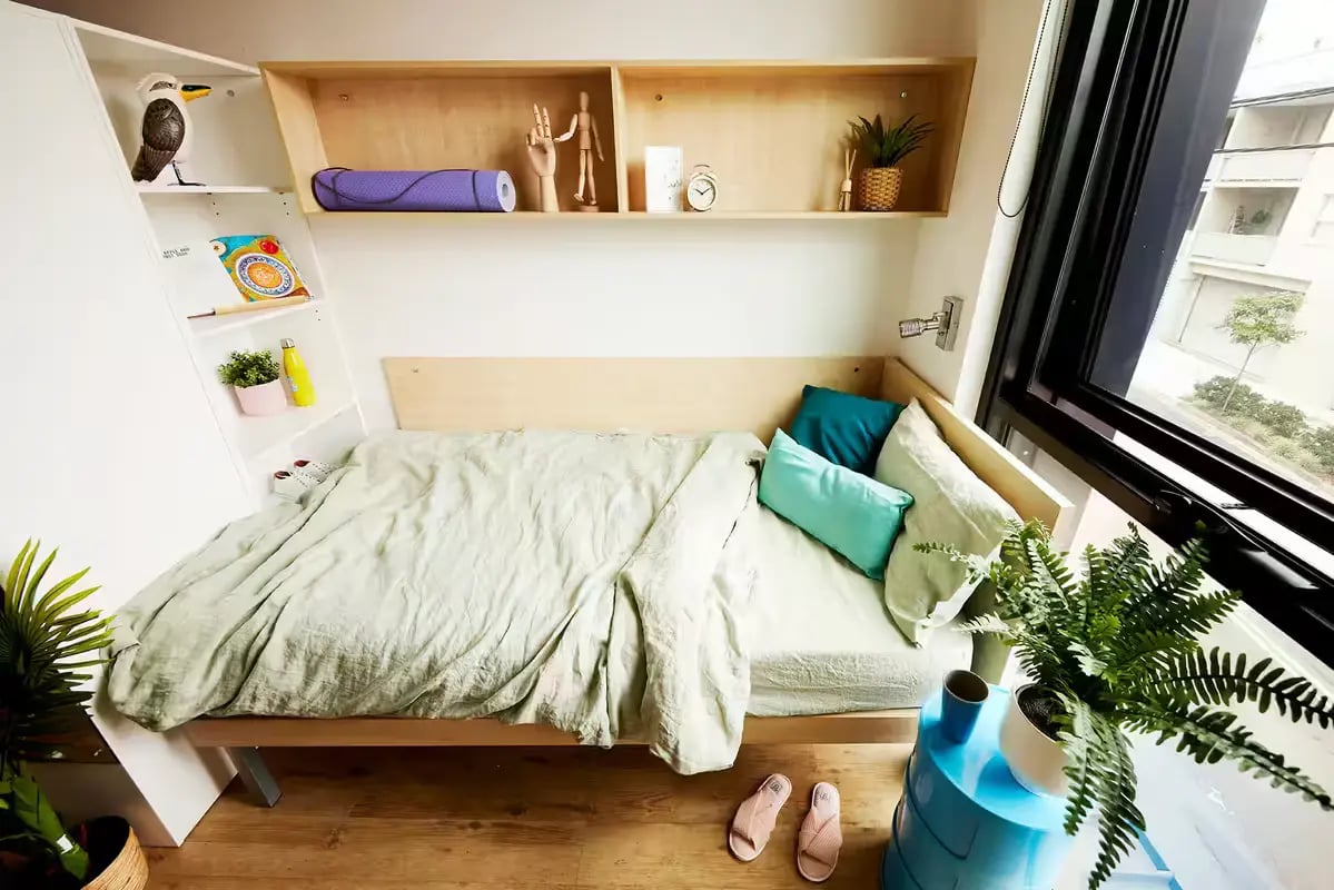 Bed with pillows and shelves with decor bedroom at Scape Cleveland in Sydney Student Accommodation