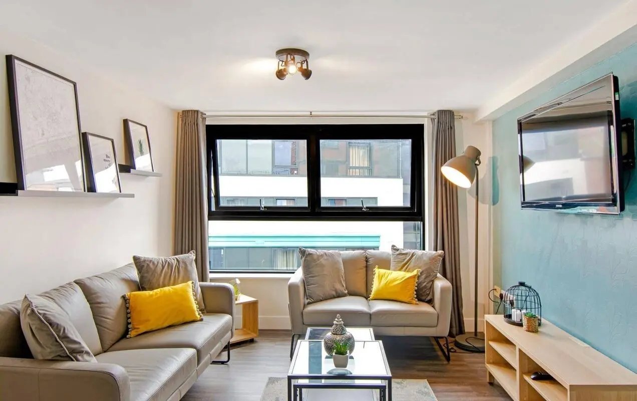 Two grey sofas yellow cushions coffee table living room at The Triangle in Leeds Student Accommodation