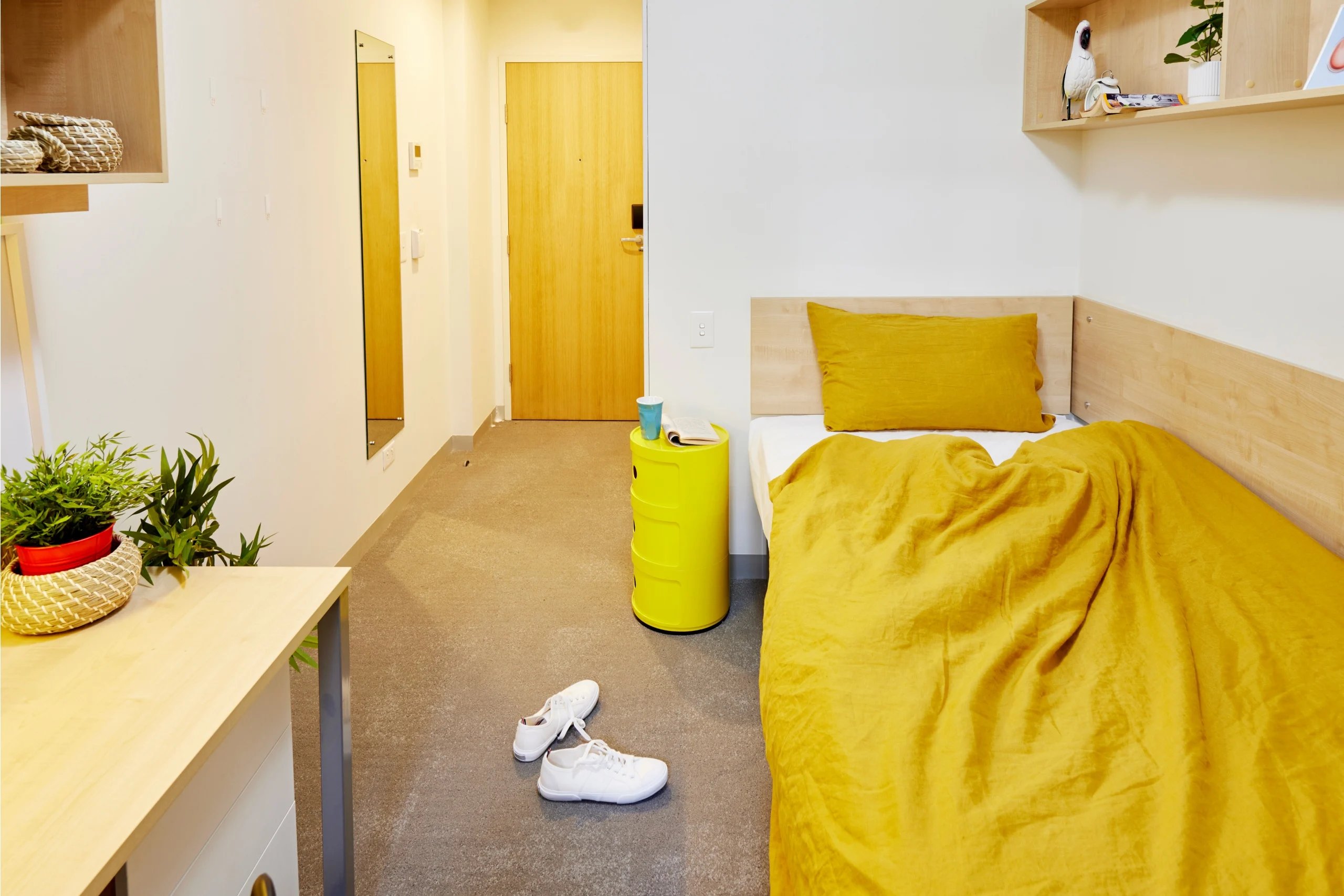 Bed with yellow duvet shoes and yellow storage bedroom at Scape Sydney Central in Sydney Student Accommodation
