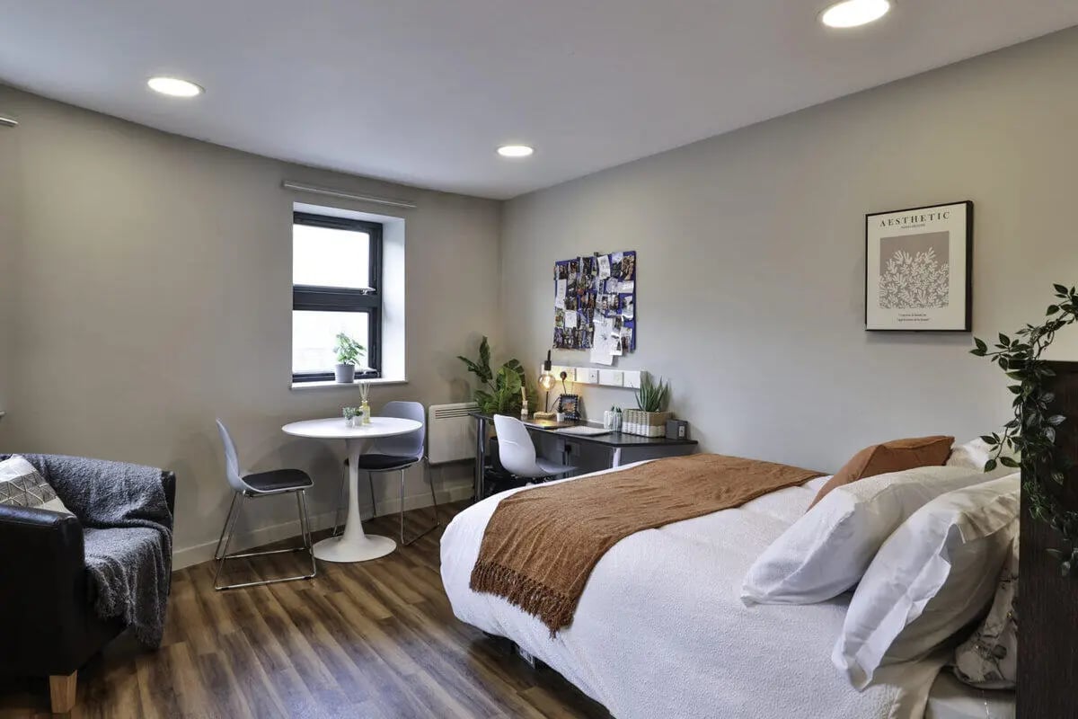Bed desk table chairs armchair living room bedroom at Ladybarn House in Manchester Student Accommodation
