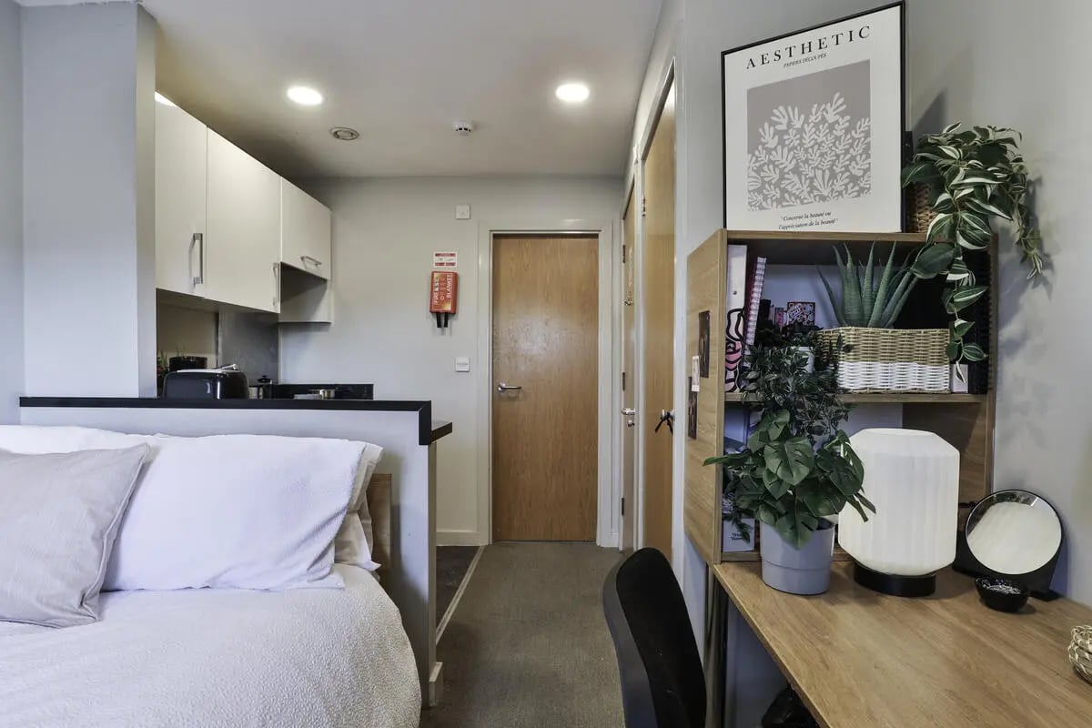 Bed kitchen doors study area and desk at Ladybarn House in Manchester Student Accommodation