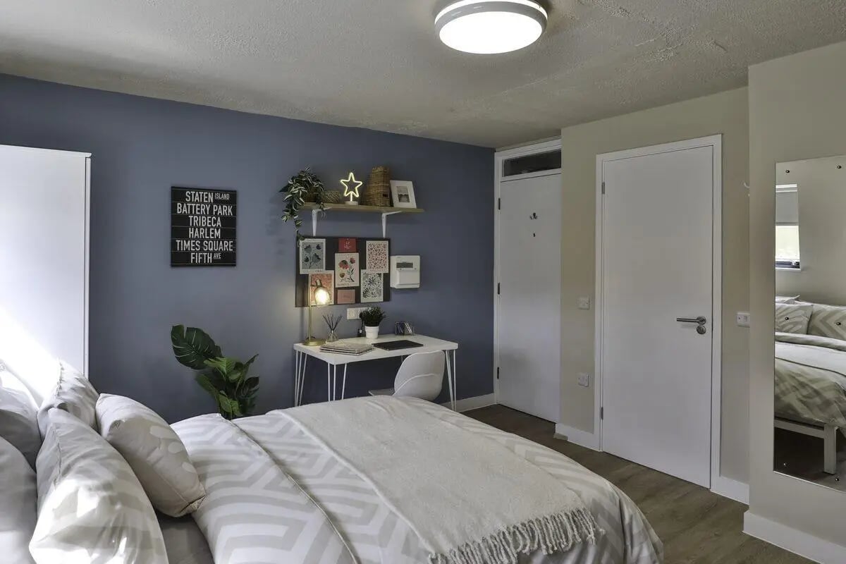 Bed desk plant wall art and mirror bedroom at Ladybarn House in Manchester Student Accommodation