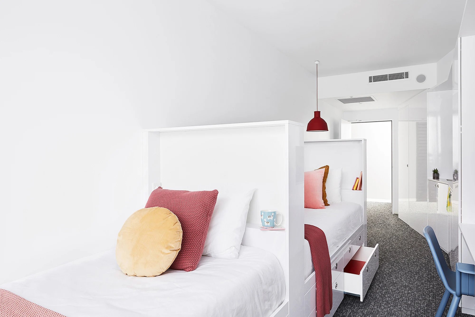 Two beds with pillows and red blankets bedroom at Scape Toowong in Brisbane Student Accommodation