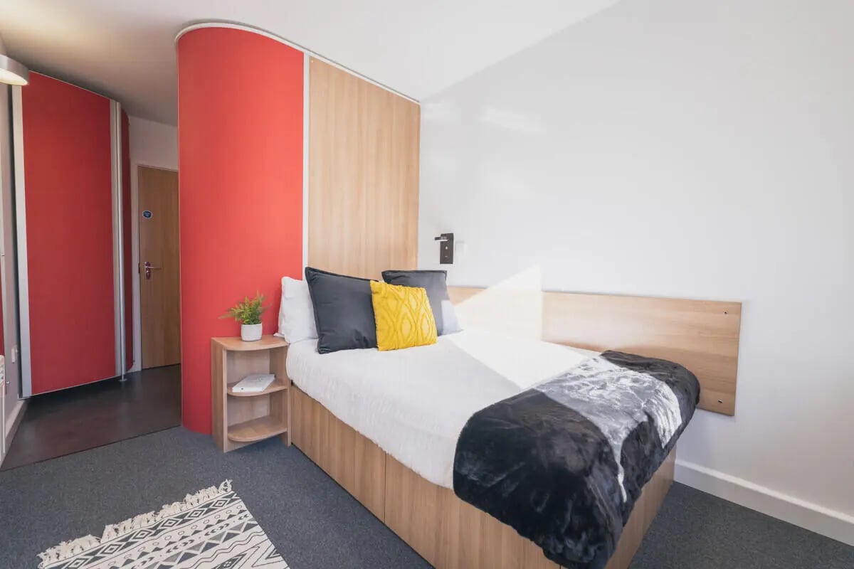 Bed with pillows blanket rug and bedside table bedroom at The Park in Oxford Student Accommodation