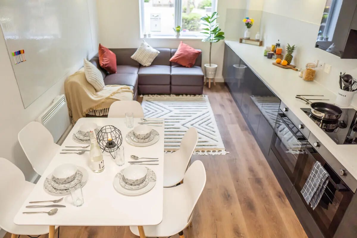 Dining table sectional sofa kitchen living space at The Park in Oxford Student Accommodation