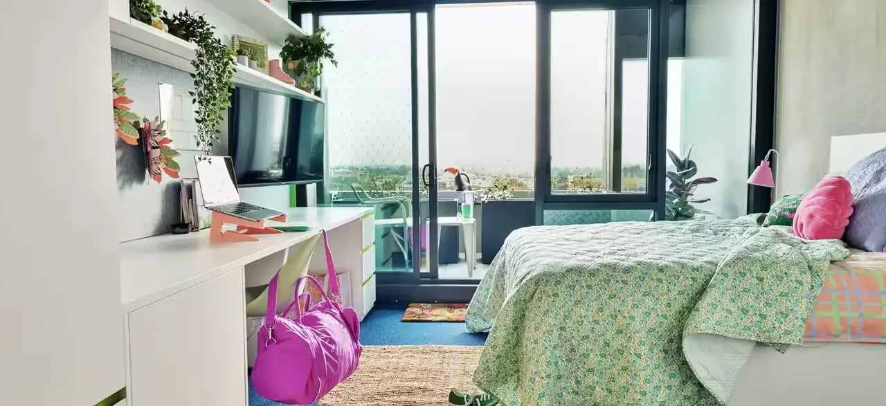 Bed desk laptop plants and balcony bedroom at Scape Victoria Street in Melbourne Student Accommodation