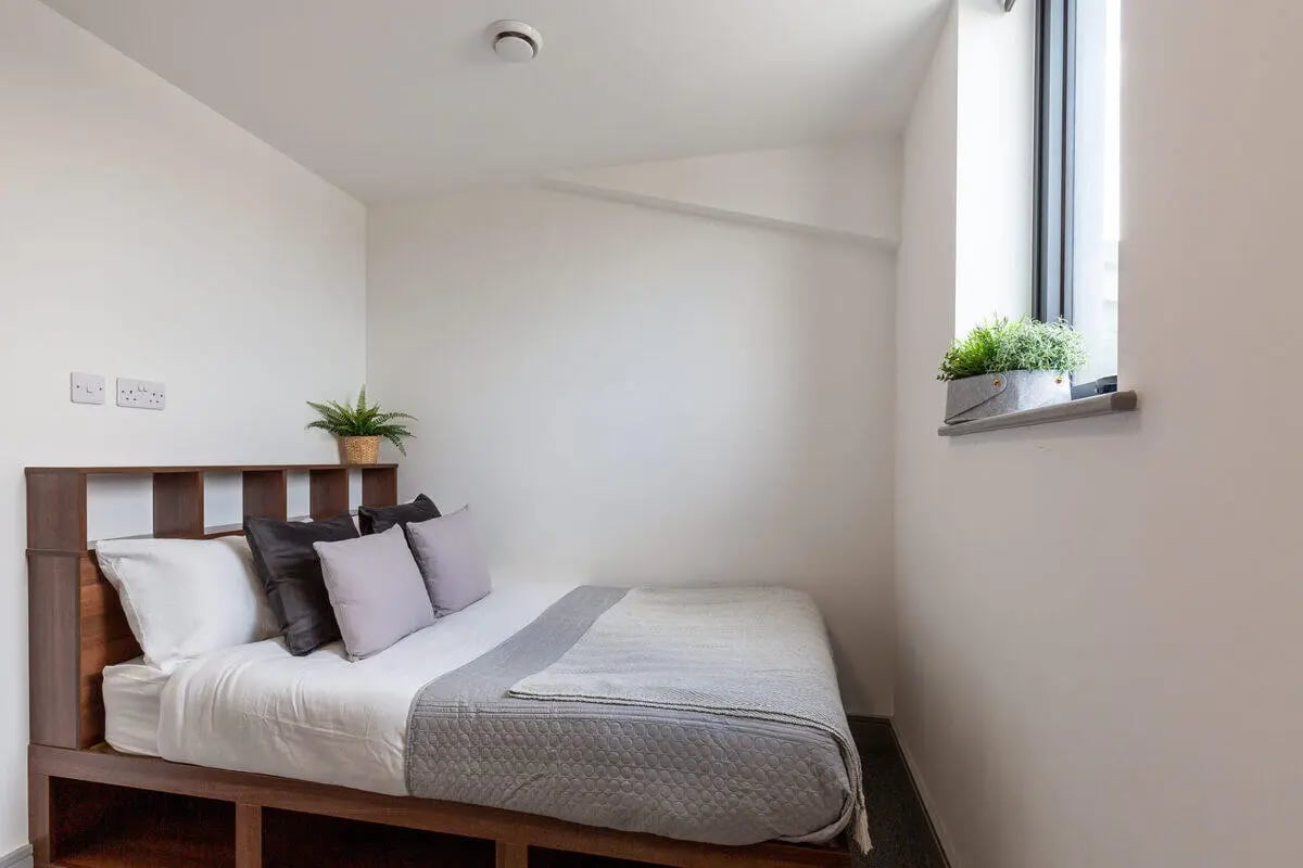 Bed with pillows and plants Bedroom at The Foundry in Leeds Student Accommodation