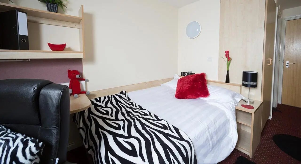 Bed sofa bedside table lamp bedroom at Q3 Apartments in Manchester Student Accommodation
