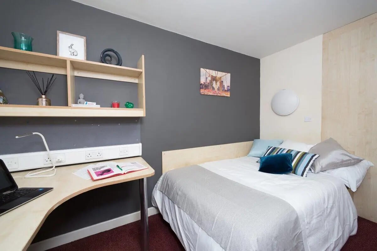Bed desk shelves laptop books artwork bedroom at Aspect 3 Apartments in Sheffield Student Accommodation