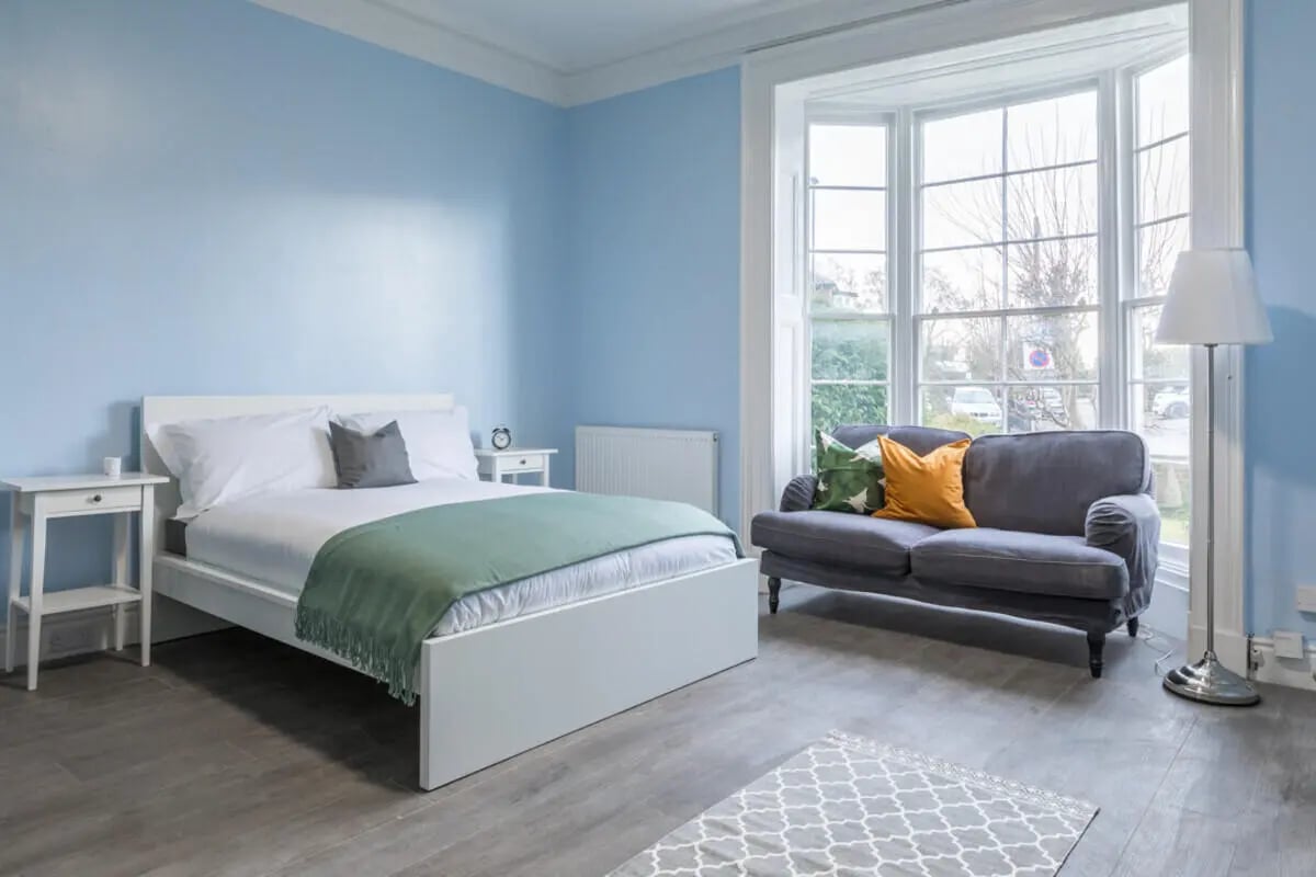 Bed, couch, floor lamp, bay window bedroom at Holgate Road in York Student Accommodation