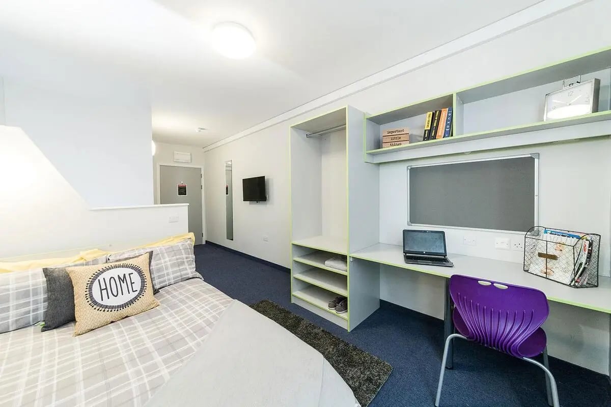 Bed desk wardrobe shelving clock and chair student room at Quayside Court in Newcastle Upon Tyne Student Accommodation