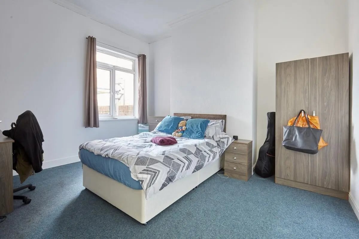 Bed with desk wardrobe and bags bedroom at Humber Portfolio in Hull Student Accommodation