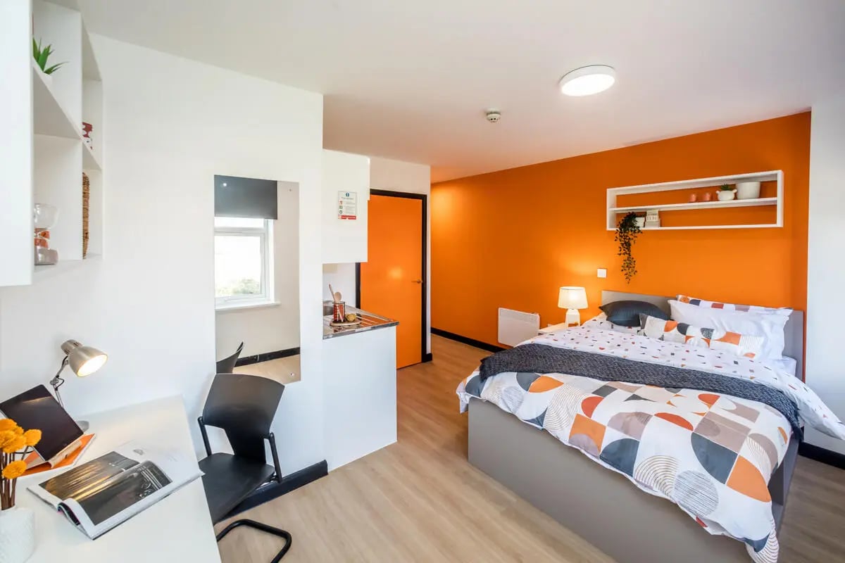 Bed desk chair orange wall bedroom at Crosstrend House in Lincoln Student Accommodation
