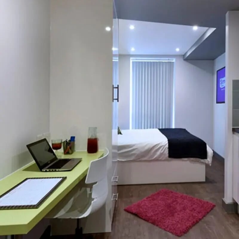 Desk with laptop and bed bedroom at The Courtyard Block B in Huddersfield Student Accommodation